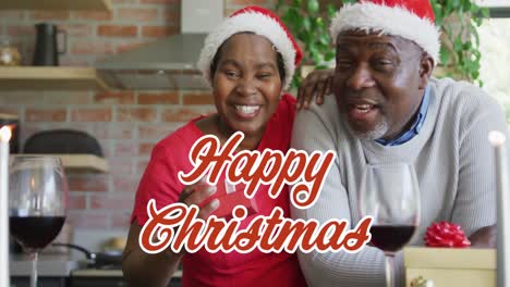 Animation-of-christmas-greetings-text-over-african-american-couple-in-santa-hats-at-christmas