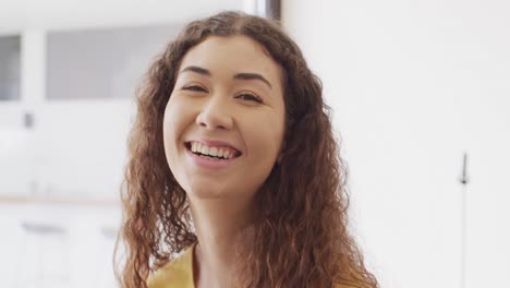 Video-portrait-of-happy-biracial-woman-smiling-to-camera-indoors