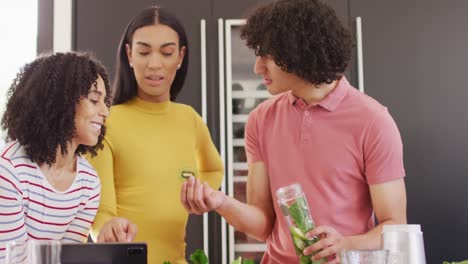 Happy-group-of-diverse-friends-preparing-healthy-drink-in-kitchen-together