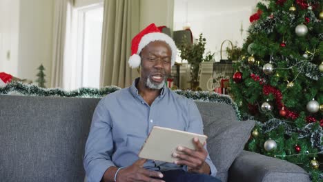 Glücklicher-älterer-Afroamerikanischer-Mann,-Der-Zu-Weihnachten-Ein-Tablet-Benutzt