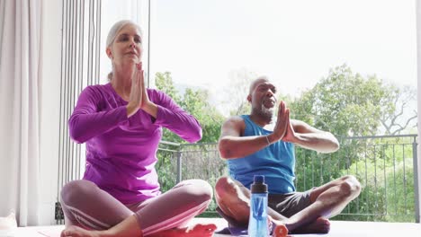 Happy-senior-diverse-couple-practicing-yoga-and-meditating