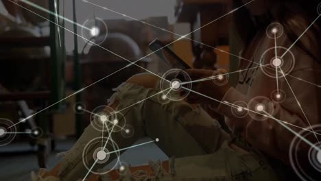 Animation-of-network-of-connections-with-icons-over-biracial-woman-using-tablet