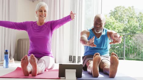 Happy-senior-diverse-couple-practicing-yoga-and-stretching