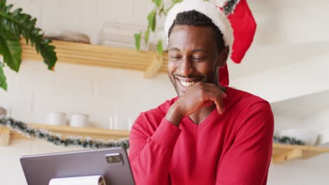 Feliz-Hombre-Afroamericano-Con-Sombrero-De-Santa,-Usando-Tableta-Para-Videollamada