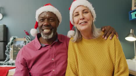Portrait-of-happy-senior-diverse-couple-with-santa-hats