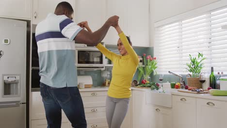 Video-Eines-Glücklichen,-Vielfältigen-Paares,-Das-Spaß-Beim-Gemeinsamen-Tanzen-In-Der-Küche-Hat