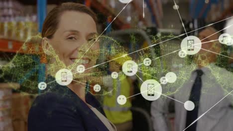Animation-of-glowing-dna-helix,-connected-icons-over-smiling-caucasian-businesswoman-in-warehouse