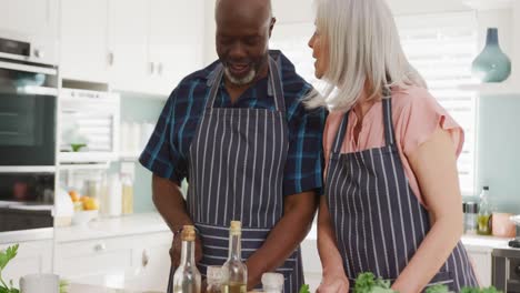 Happy-senior-diverse-couple-cooking-and-working-in-garden