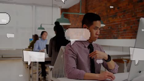 Animation-Schwebender-Sprechblasen-über-Einem-Asiatischen-Geschäftsmann,-Der-Im-Büro-Einen-Laptop-Benutzt