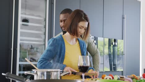 Video-of-diverse-couple-preparing-food-together-in-kitchen-at-home