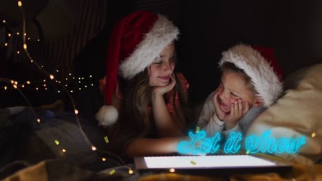 Animation-of-let-it-snow-text-and-confetti-over-caucasian-children-wearing-santa-hats