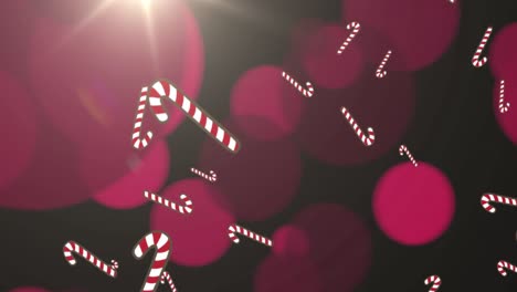 Animation-of-christmas-candy-canes-falling-and-pink-spotlights-on-black-background