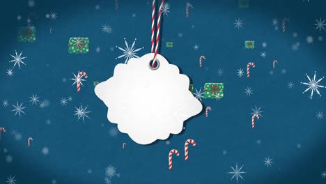 Animation-of-christmas-tag-with-copy-space,-decorations-and-snow-falling-on-blue-background