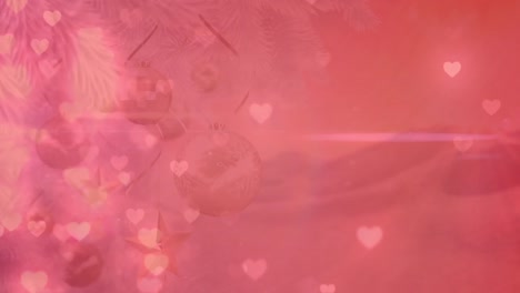 Animation-of-glowing-heart-icons-over-decorated-christmas-tree-branch-against-pink-background