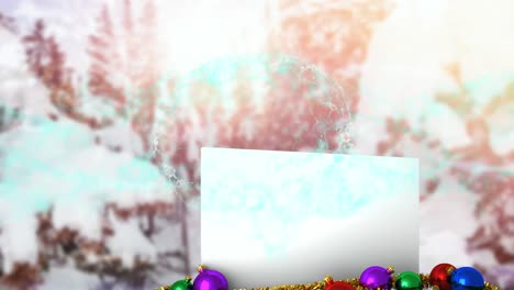 Animation-of-snow-falling-over-white-card-with-copy-space-and-christmas-decoration-in-winter-scenery