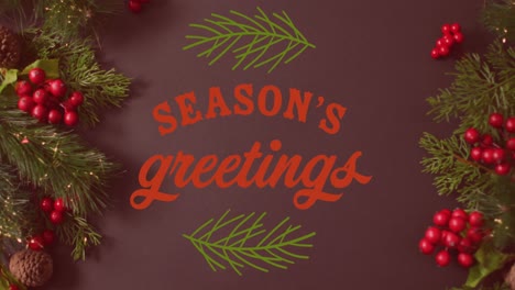 Animation-of-seasons-greetings-text-banner-over-christmas-decorations-on-grey-surface