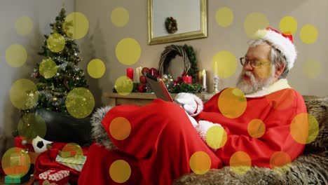Animation-of-dots-moving-over-santa-claus-reading-in-room-with-christmas-decorations