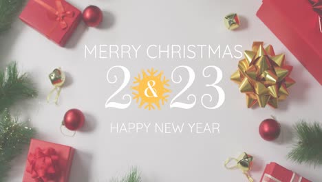 Animation-Des-Textes-„Frohe-Weihnachten-Und-Ein-Glückliches-Neues-Jahr-2023“-über-Weihnachtsgeschenken-Und-Dekorationen