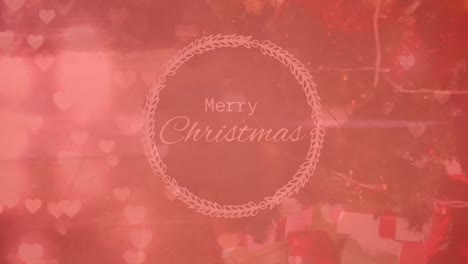 Animation-of-glowing-heart-icons-over-merry-christmas-text-banner-against-decorated-christmas-tree