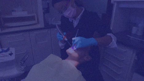 Animation-of-pattern-and-purple-tint-over-patient-in-dentist-chair-and-female-dentist