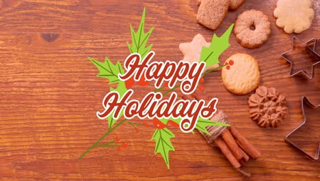 Animation-of-happy-holidays-text-with-leaves-over-cinnamons,-cookies-and-milk-on-wooden-table