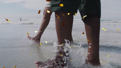 Animation-of-christmas-confetti-falling-over-senior-biracial-couple-on-beach