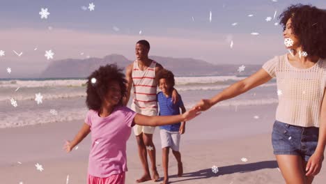 Animation-of-christmas-snow-falling-over-biracial-couple-with-son-and-daughter-on-beach