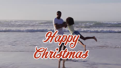 Animation-Eines-Weihnachtsgrußtextes-über-Einem-Afroamerikanischen-Mann-Mit-Tochter-Am-Strand