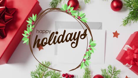 Animation-of-happy-holidays-text-over-christmas-decorations-and-envelopes