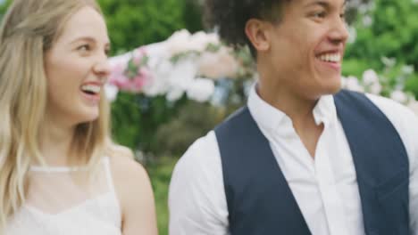 Happy-diverse-couple-in-garden-on-sunny-day-at-wedding