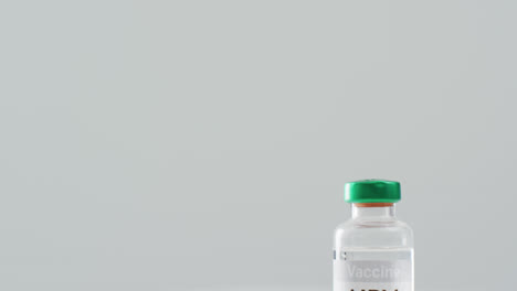 Video-Nahaufnahme-Eines-HPV-Impfstofffläschchens-Und-Einer-Spritze-Auf-Grauem-Hintergrund-Mit-Kopierraum