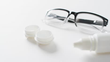 Video-Von-Brillen,-Kontaktlinsenbehälter-Und-Linsenlösung-Auf-Weißem-Hintergrund-Mit-Kopierraum