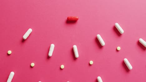 Video-of-a-variety-of-pills-arranged-on-pink-background-with-copy-space
