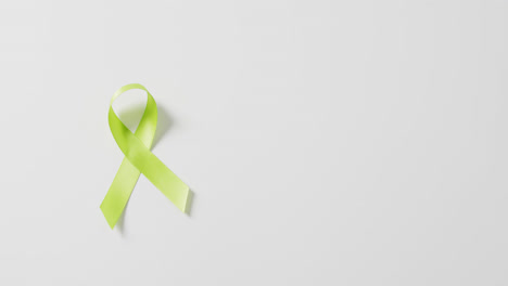 Video-of-pale-green-std-awareness-ribbon-on-white-background-with-copy-space