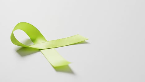 Video-of-pale-green-std-awareness-ribbon-on-white-background-with-copy-space