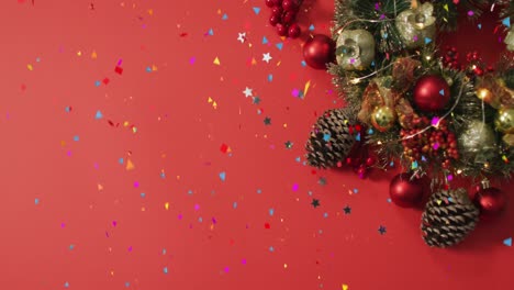 Animation-of-confetti-and-stars-falling-over-christmas-decorations