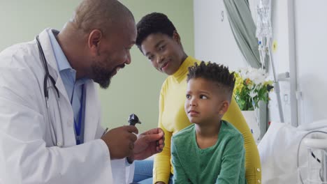 Médico-Varón-Afroamericano-Examinando-A-Un-Paciente-Infantil-En-El-Hospital