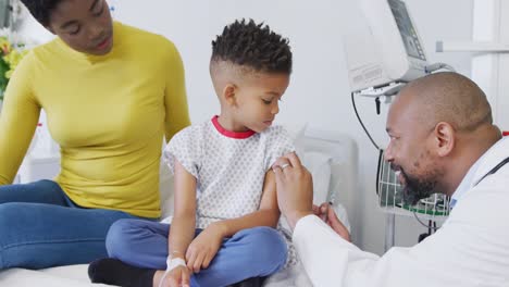 Médico-Varón-Afroamericano-Vacunando-A-Un-Paciente-Infantil-En-El-Hospital