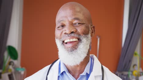 Portrait-of-happy-african-american-male-doctor-smiling-and-looking-at-camera-at-hospital
