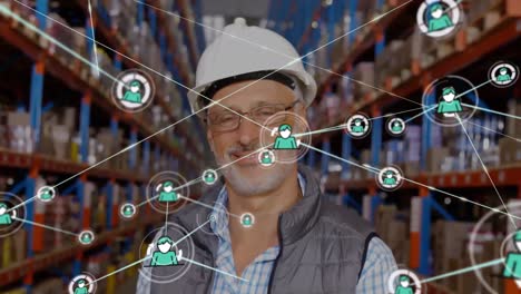 Animation-of-network-of-connections-with-icons-over-caucasian-worker-in-warehouse