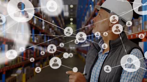 Animation-of-network-of-profile-icons-over-caucasian-male-supervisor-checking-stock-at-warehouse