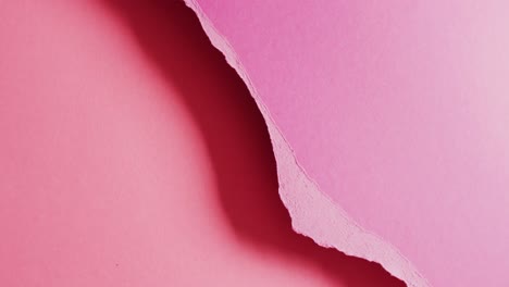 Video-of-close-up-of-torn-pieces-of-pink-paper-background