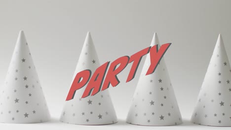 Animation-Von-Partytext-über-Weißen-Partyhüten-Im-Hintergrund