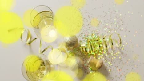 Animation-of-spots-of-light,-confetti-and-champagne-glasses