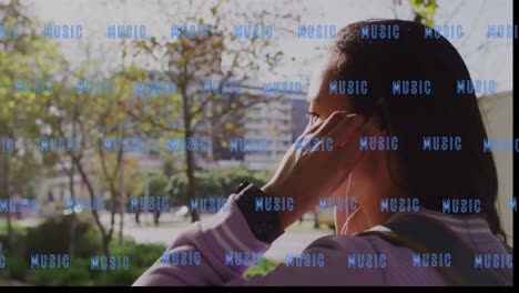 Animation-of-music-text-over-biracial-woman-using-earphones-in-city