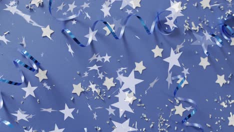 Animation-of-stars-falling-over-party-streamers-on-blue-background