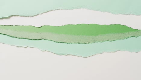Video-Einer-Nahaufnahme-Von-Zerrissenen-Stücken-Grünem-Und-Weißem-Papierhintergrund