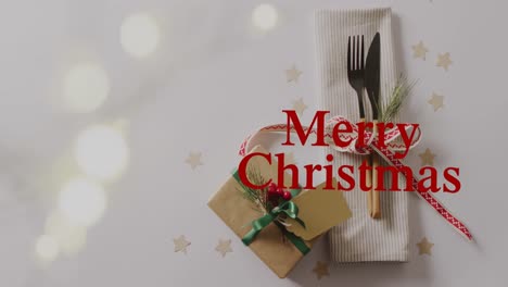 Animation-of-christmas-greetings-text-over-christmas-place-setting-and-present