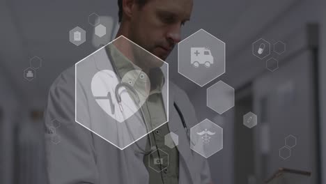 Animation-Mehrerer-Medizinischer-Symbole-über-Einem-Kaukasischen-Männlichen-Arzt,-Der-Im-Krankenhaus-Ein-Digitales-Tablet-Verwendet