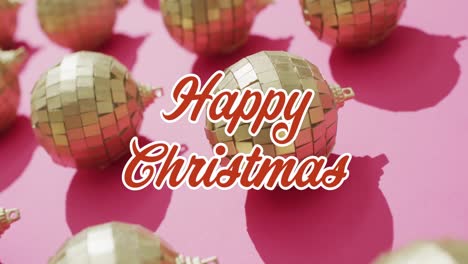 Animation-of-christmas-greetings-text-over-christmas-gold-baubles